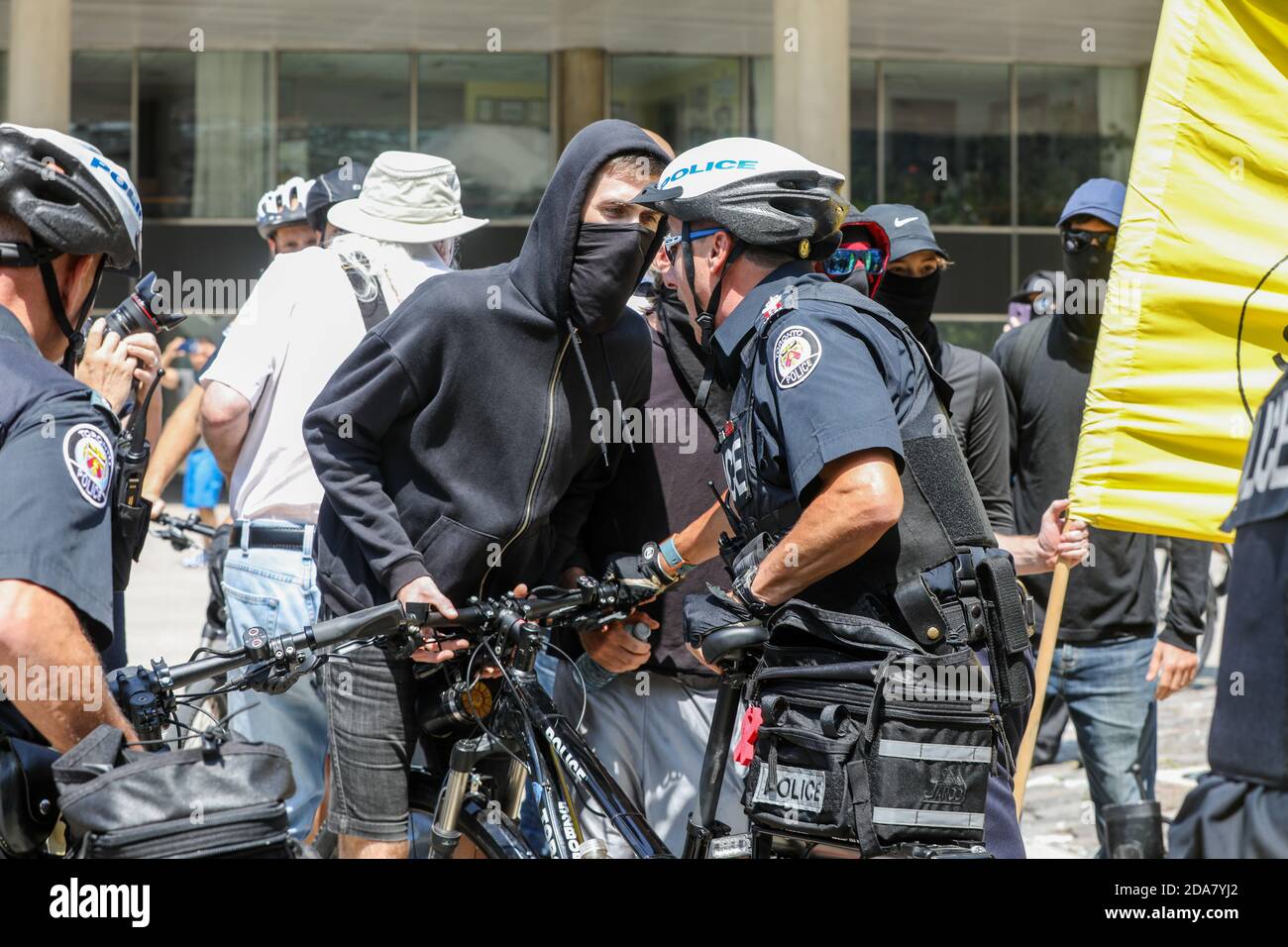Des manifestants masqués affrontent la police pendant la manifestation.UN rassemblement « Stop the Hate » a été organisé par des manifestants antifascistes de l'ANTIFA à Nathan Phillip Square, en opposition à WCAI (Coalition mondiale contre l'islam) Canada, un groupe qui a organisé une manifestation le même jour. Banque D'Images