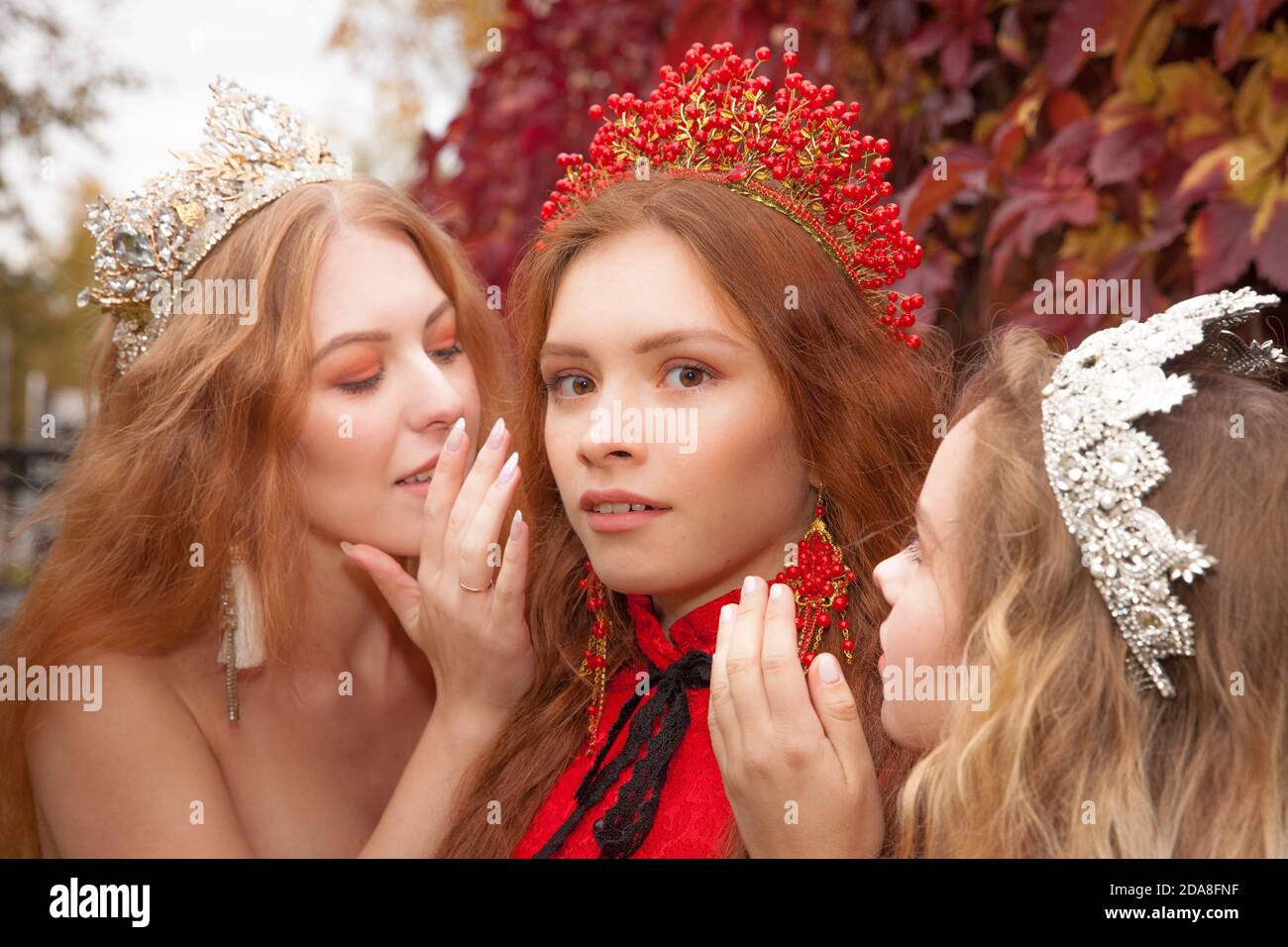 Les filles russes sont belles. Traditions nationales russes. Sœurs en couronnes. Épouses de l'étranger. Petites amies vêtues de rouge Banque D'Images