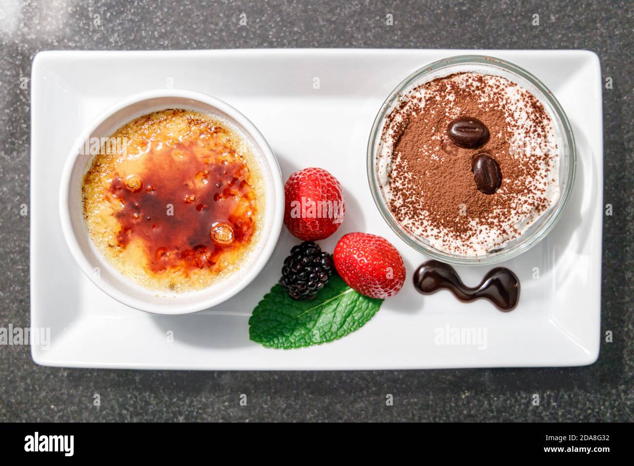 Vue de dessus de la nourriture maison, crème brûlée et crème de chockolate avec des feuilles de fraise et de menthe, crème brûlée est un dessert populaire, montrant les plats Banque D'Images