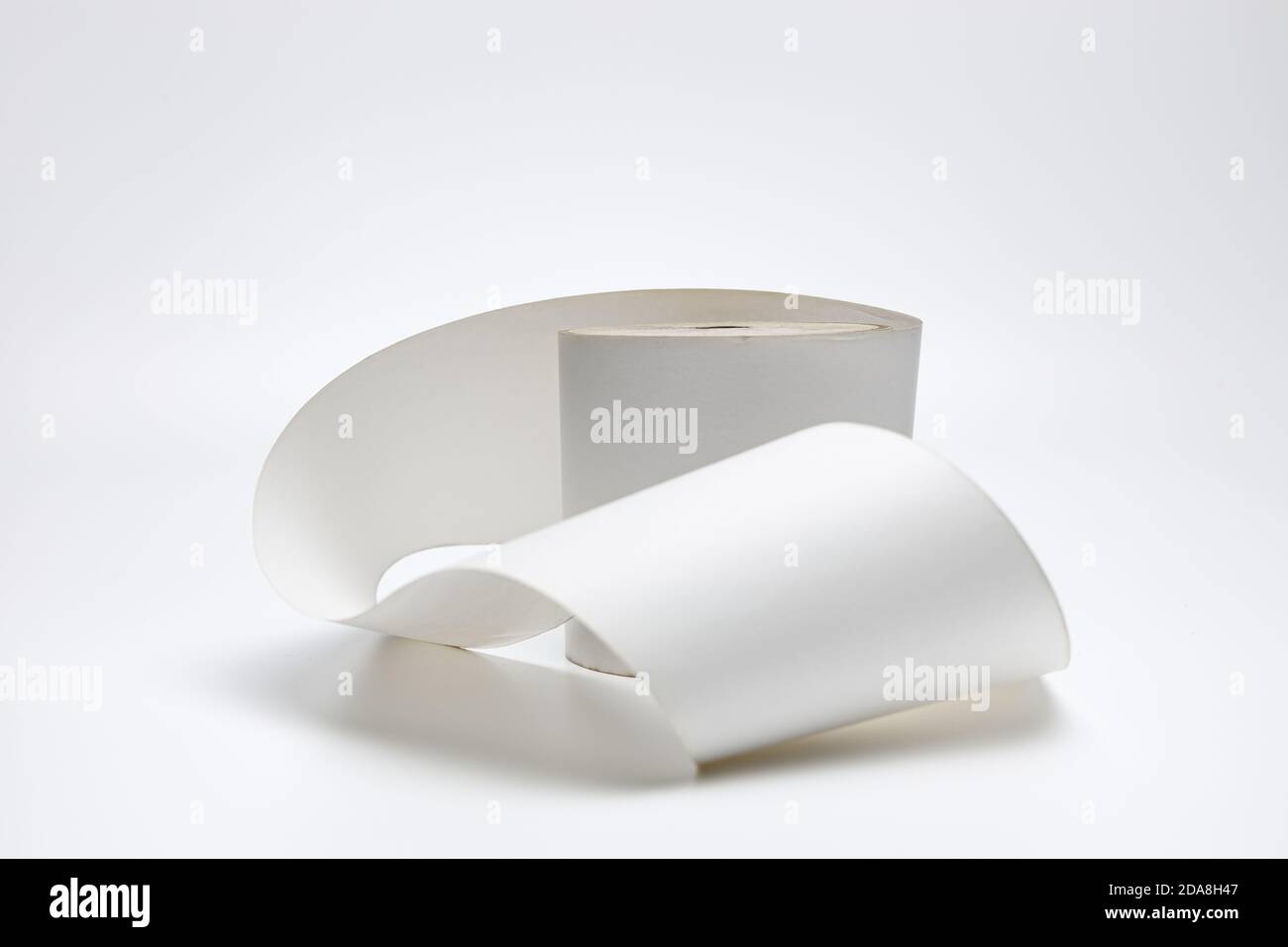 Un seul rouleau de papier thermique pour l'impression des reçus sur fond blanc uniforme, il est utilisé dans les caisses enregistreuses et les imprimantes de reçus et pollue le Banque D'Images