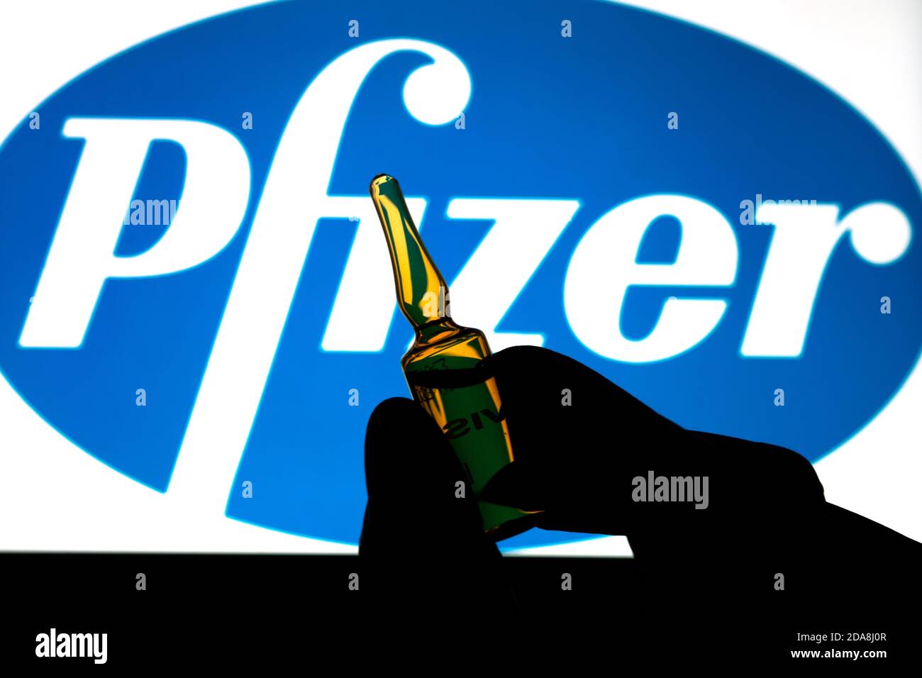 Société pharmaceutique Pfizer de vaccins contre le coronavirus. Logo Pfizer avec vaccin à main. Banque D'Images