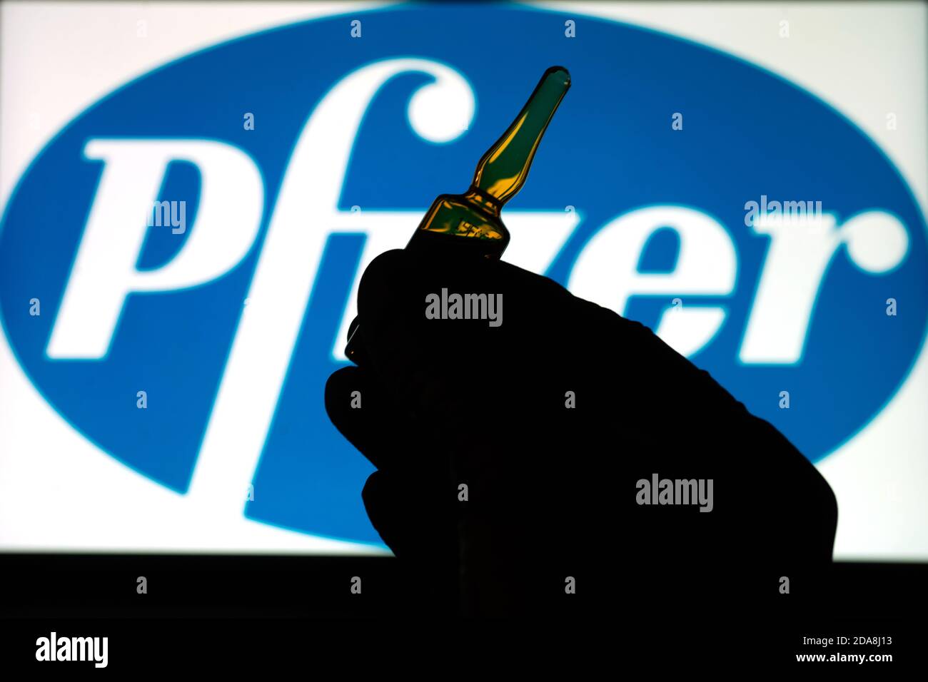 Société pharmaceutique Pfizer de vaccins contre le coronavirus. Logo Pfizer avec vaccin à main. Banque D'Images