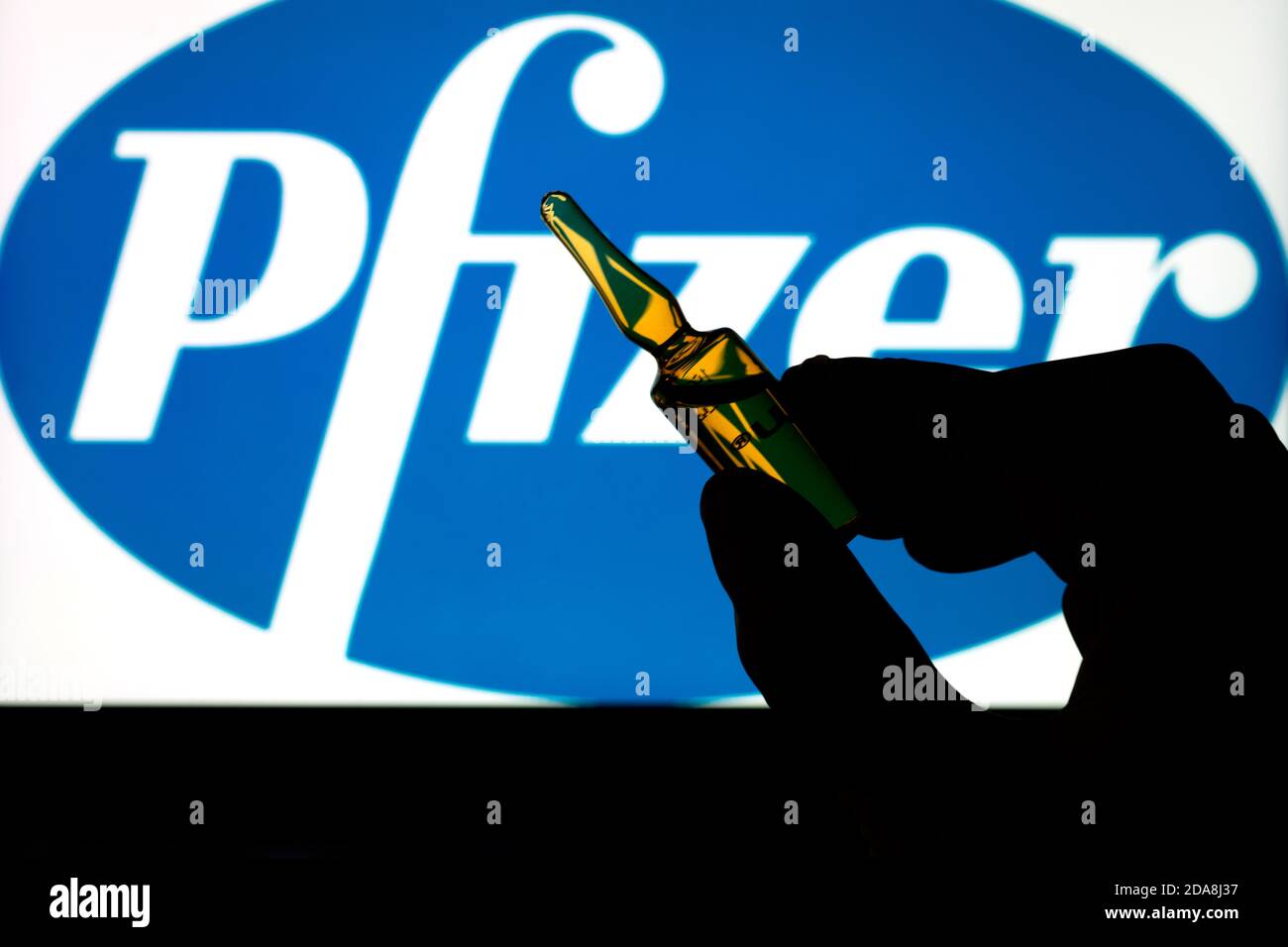 Société pharmaceutique Pfizer de vaccins contre le coronavirus. Logo Pfizer avec vaccin à main. Banque D'Images