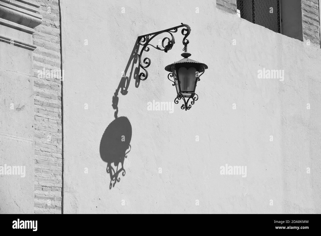 L'ombre d'une vieille lampe contre un mur blanc dans cette photo prise à Oliva en Espagne. Banque D'Images