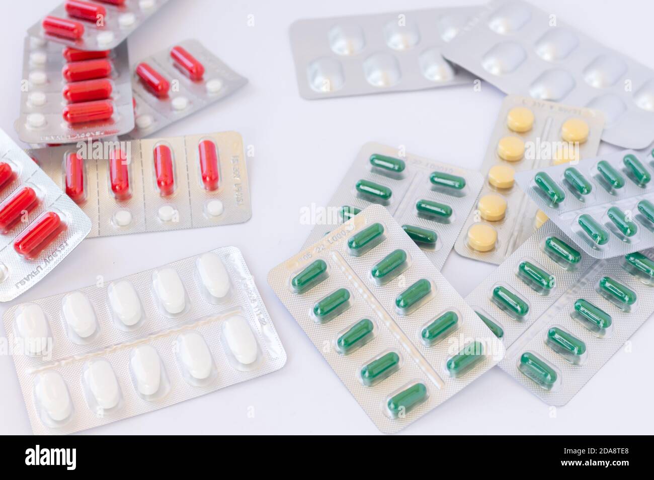 Beaucoup de pilules de médicaments avec des couleurs, des tailles et des formes diferentes dans les plaquettes thermoformées boîtes désordonnées. Banque D'Images