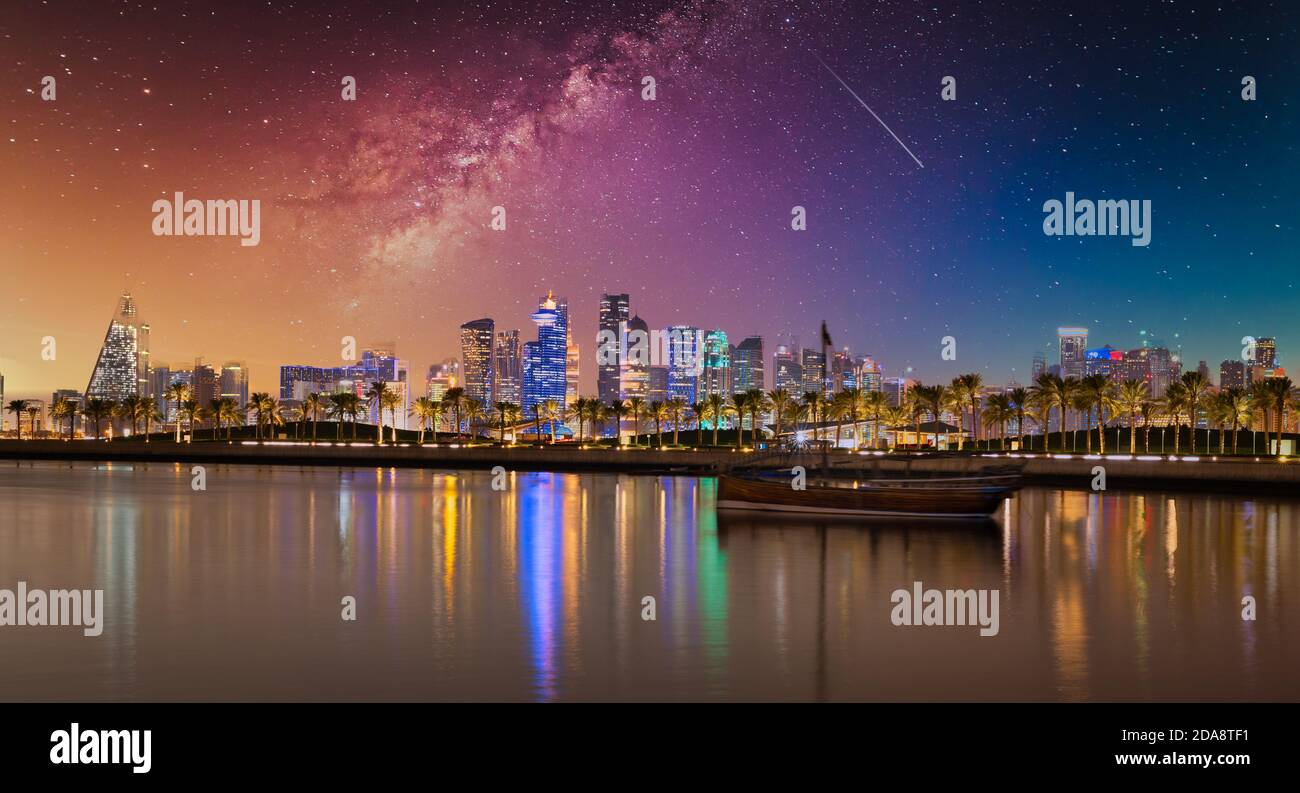 Doha Qatar la nuit montrant les gratte-ciel illuminés Le golfe arabe et le dhow en premier plan avec des étoiles ciel en arrière-plan Banque D'Images