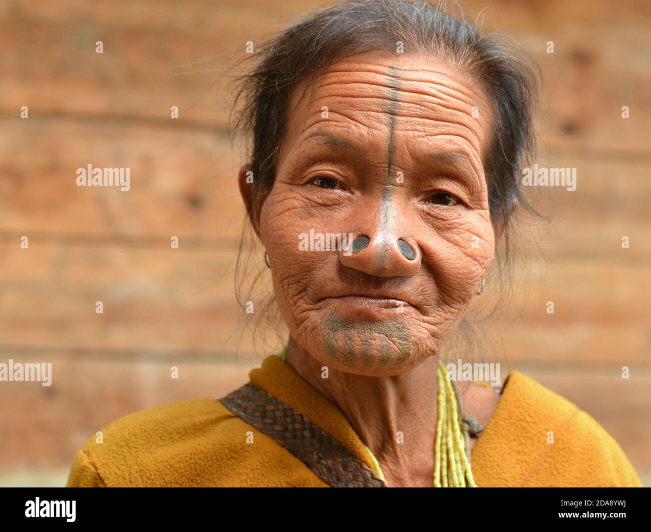 Ancienne indienne du Nord-est Apatani ethnique minoritaire femme tribale avec des bouchons de nez en bois noir et des tatouages traditionnels visage pose pour la caméra. Banque D'Images Ancienne indienne du Nord-est Apatani ethnique minoritaire femme tribale avec des bouchons de nez en bois noir et des tatouages traditionnels visage pose pour la caméra. Banque D'Images