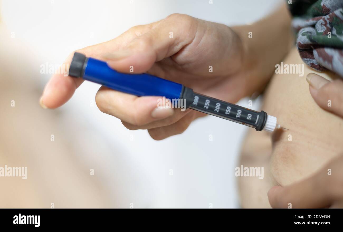 La main du patient diabétique en utilisant l'équipement médical d'injection d'insuline pour vérifier et contrôler les diabétiques à la maison. Pour la santé et la conce diabétique Banque D'Images