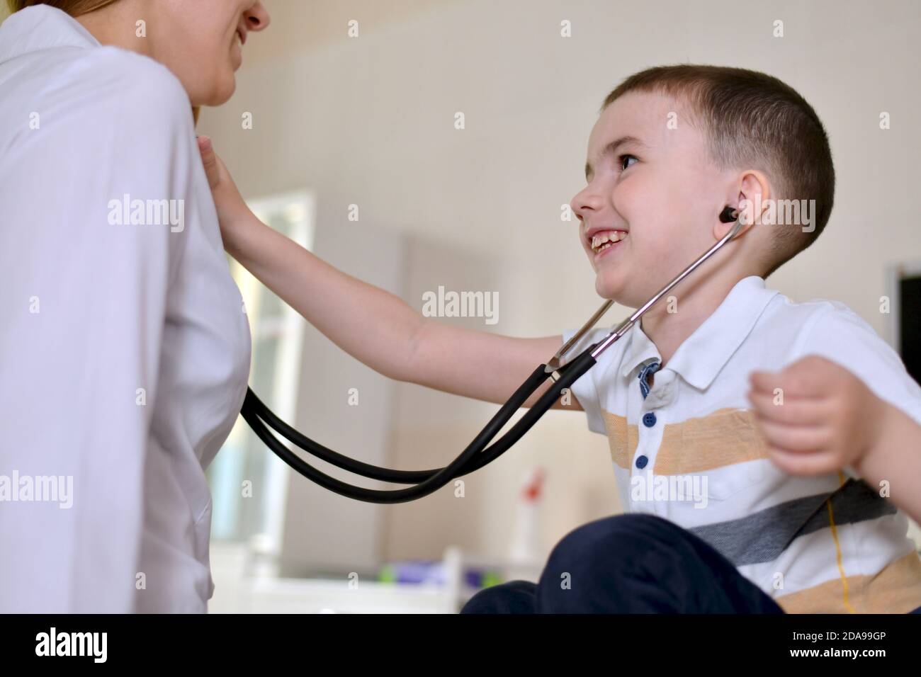 L'enfant est au rendez-vous du pédiatre. Il écoute un stéthoscope Banque D'Images