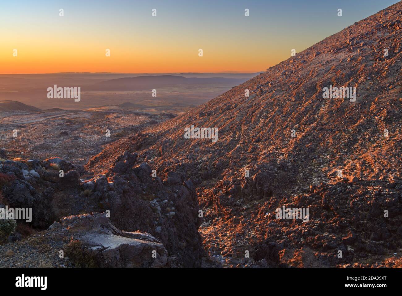 Mount Ruapehu, Nouvelle-Zélande. Une vue depuis les pentes rocheuses au coucher du soleil, en regardant sur l'étendue du plateau volcanique de l'île du Nord Banque D'Images