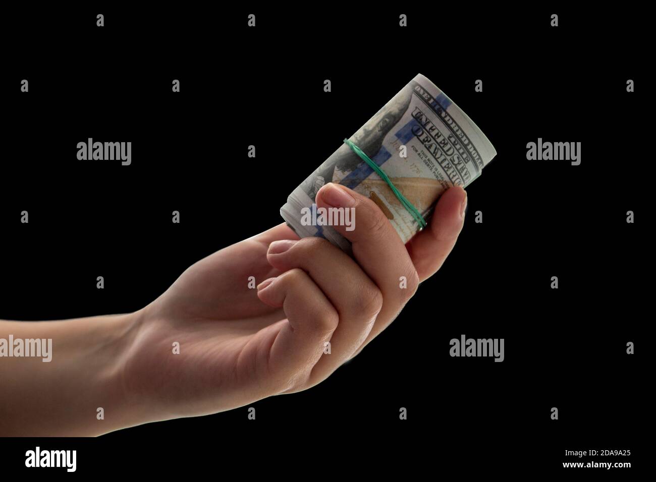 Des billets de 100 dollars torsadés à la main sur fond noir. Banque D'Images