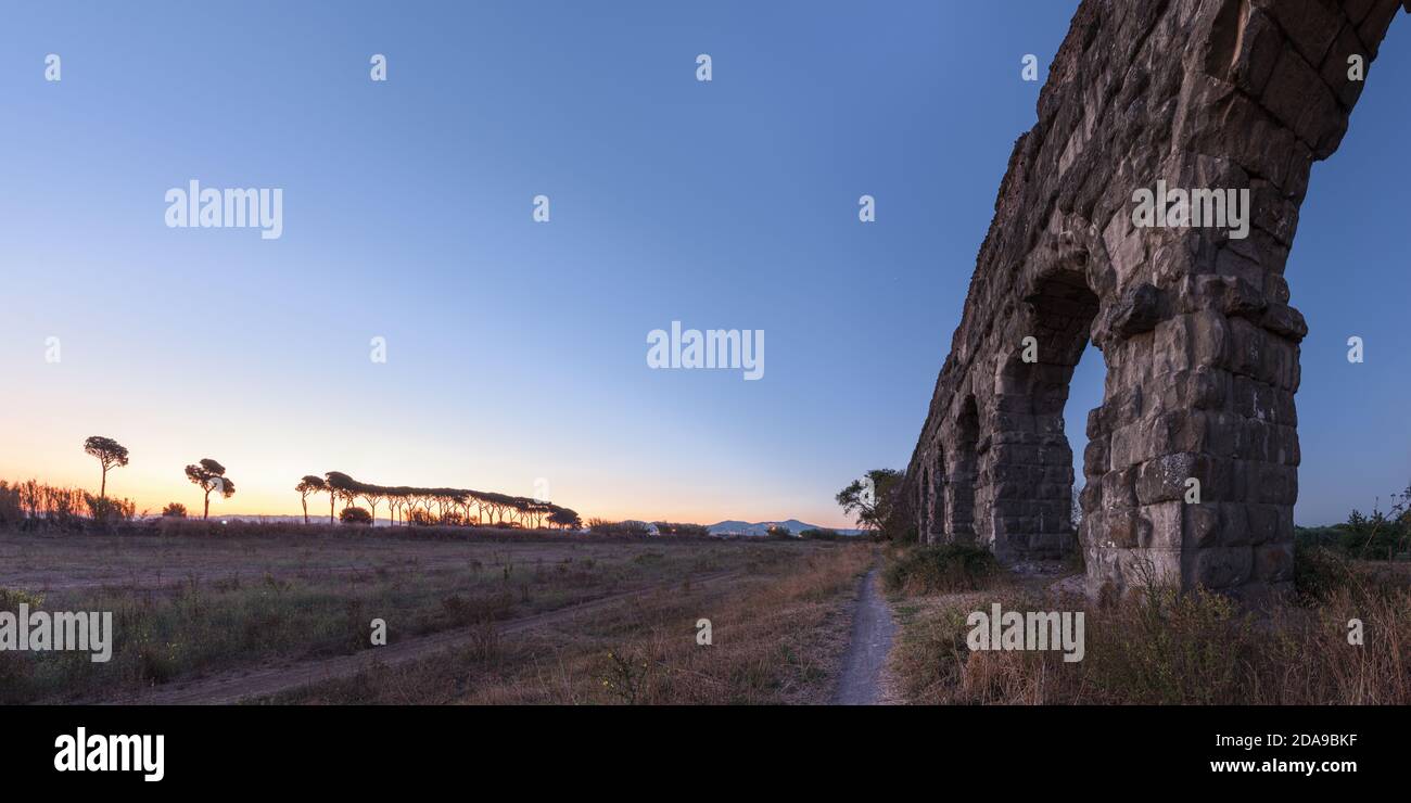 L'aqueduc romain antique de Claudius ruines dans le célèbre Parco degli Acquedotti, Rome, Italie, avec vieille structure de pipe à eau en pierre au lever du soleil dans la campagne Banque D'Images