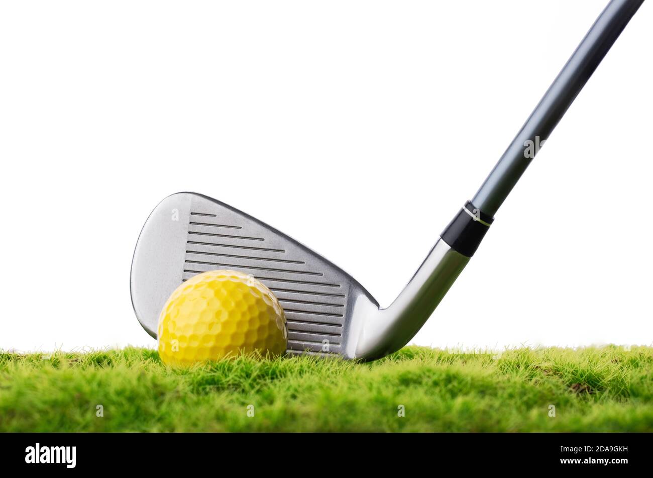 Balle de golf et bâton sur l'herbe verte isolée sur blanc Banque D'Images
