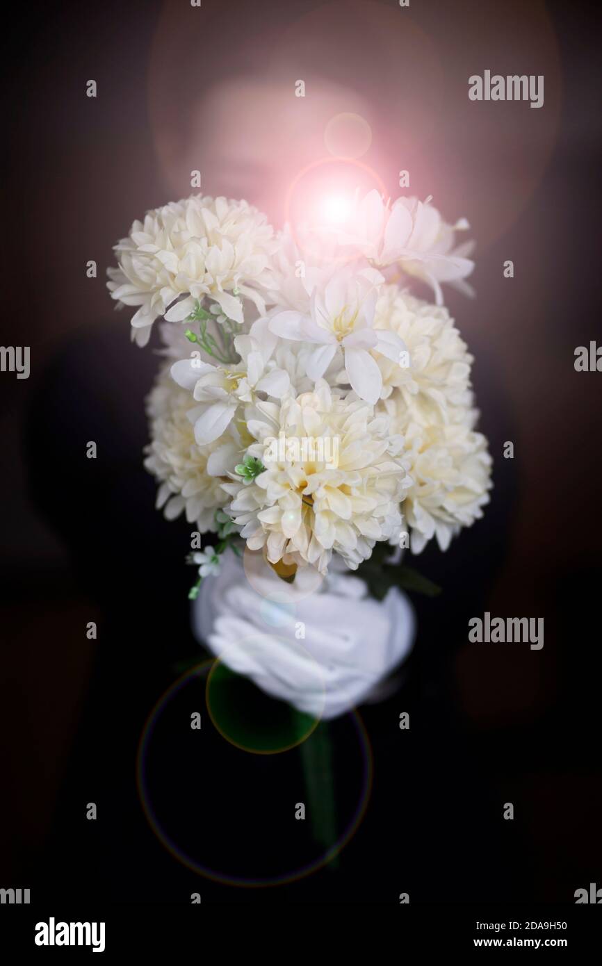 Deuil tenant des fleurs aux funérailles Banque D'Images