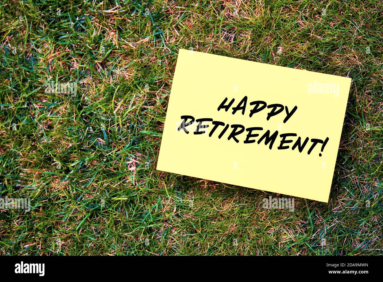 Message de bonne retraite écrit sur papier jaune sur fond d'herbe verte. Banque D'Images