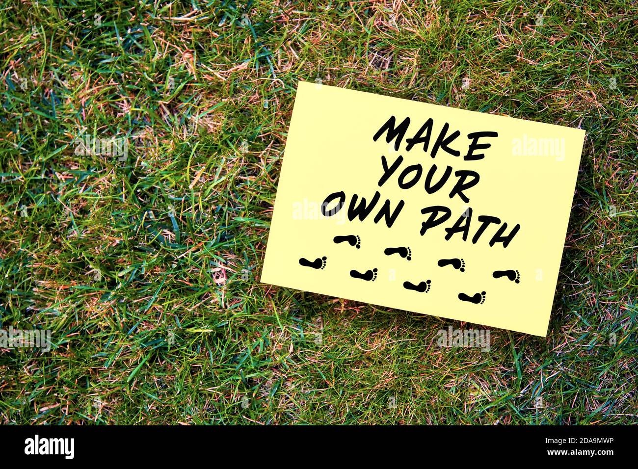 Faites votre propre message de chemin écrit sur papier jaune sur fond vert herbe. Citation motivationnelle pour créer l'avenir dans l'entreprise ou la vie. Banque D'Images