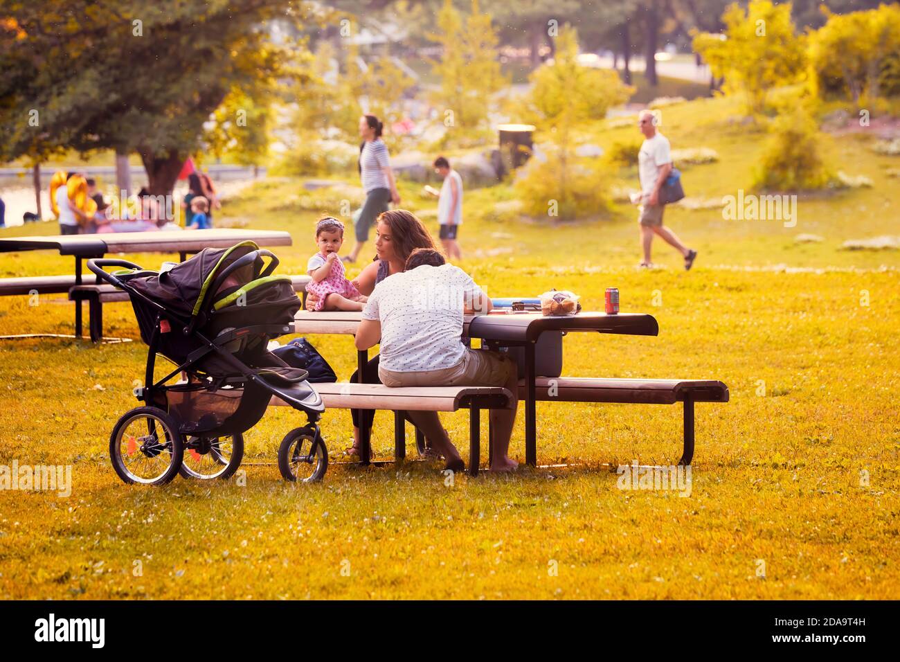 Montréal, Canada - juin 2018 : la famille canadienne avec sa mère, son père et son enfant s'assoit au banc du parc du Mont-Royal à Montréal, au Canada, sur un somme ensoleillé Banque D'Images