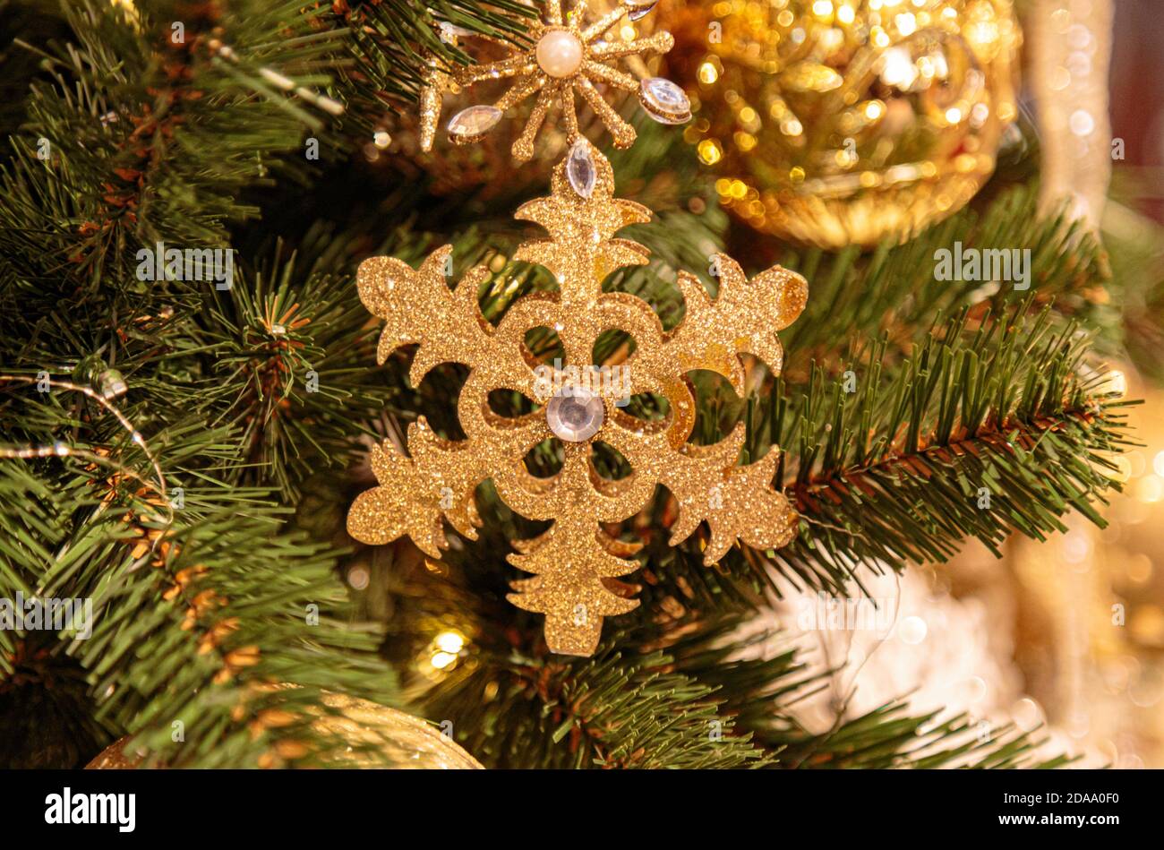 Fond de Noël avec flocon de neige doré décoratif, branches de sapin et cônes de pin Banque D'Images