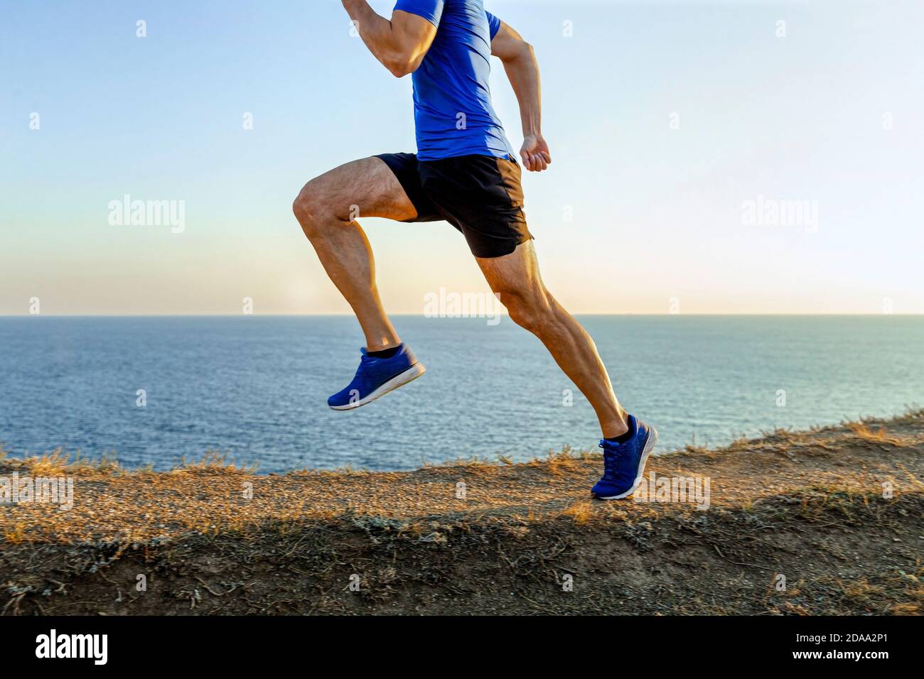 homme athlète coureur piste de montagne en arrière-plan de la mer et le ciel Banque D'Images