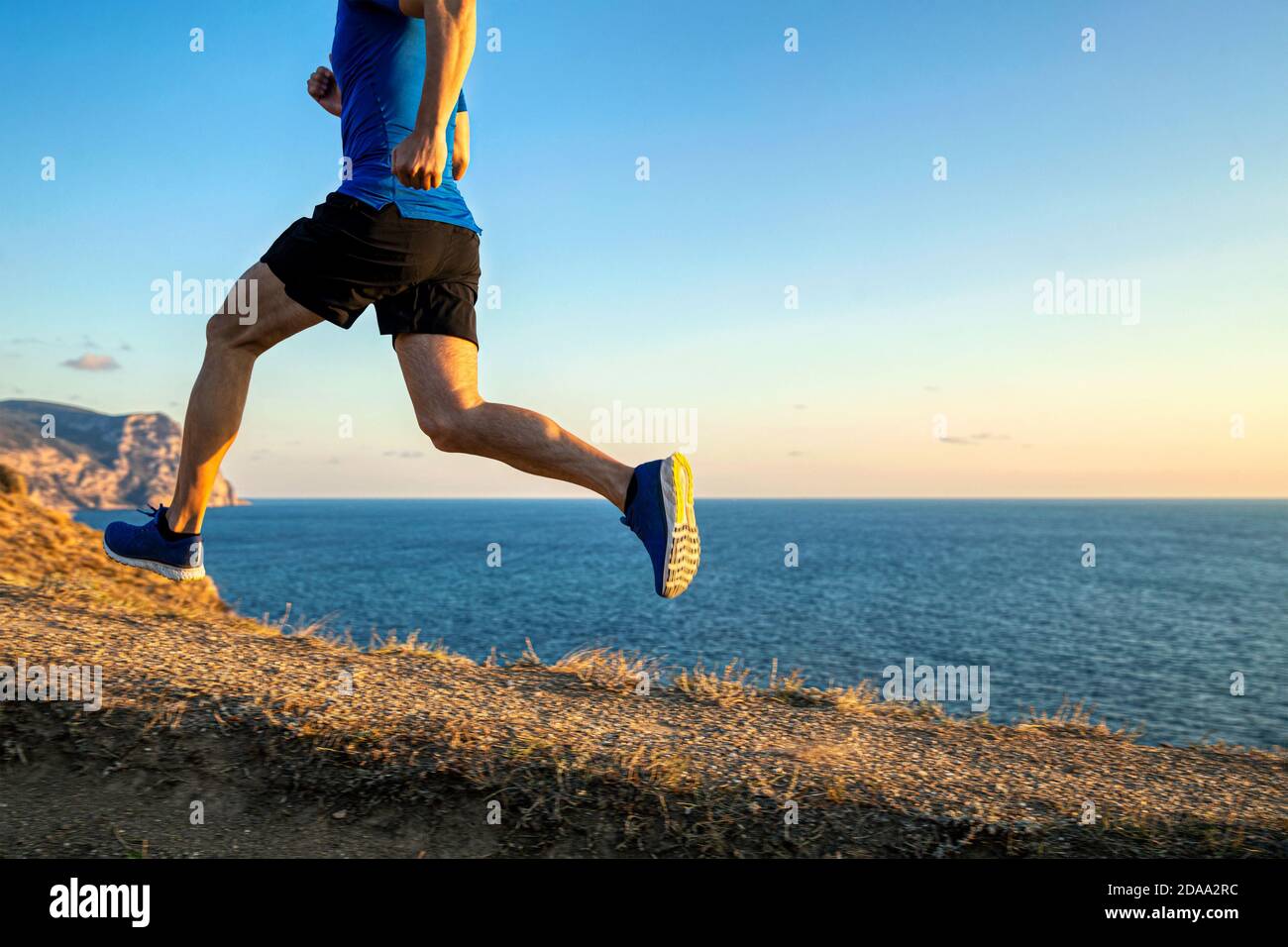athlète coureur montant en fond de ciel et de mer à coucher de soleil Banque D'Images