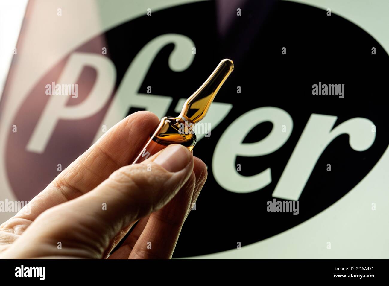 Société pharmaceutique Pfizer de vaccins contre le coronavirus. Logo Pfizer avec vaccin à main. Banque D'Images