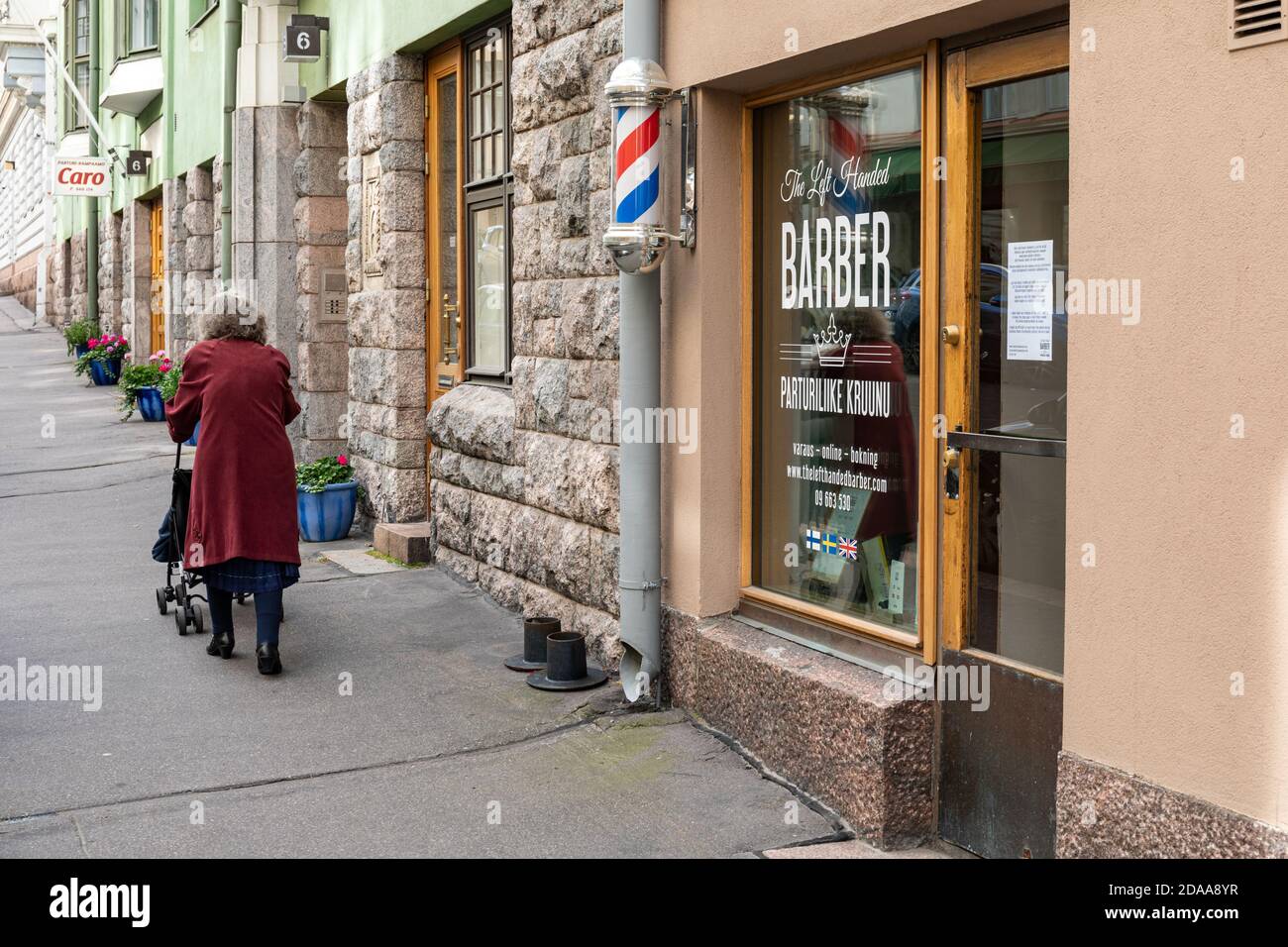 Femme âgée qui pousse un chariot dans le quartier Kruununhaka d'Helsinki, en Finlande Banque D'Images