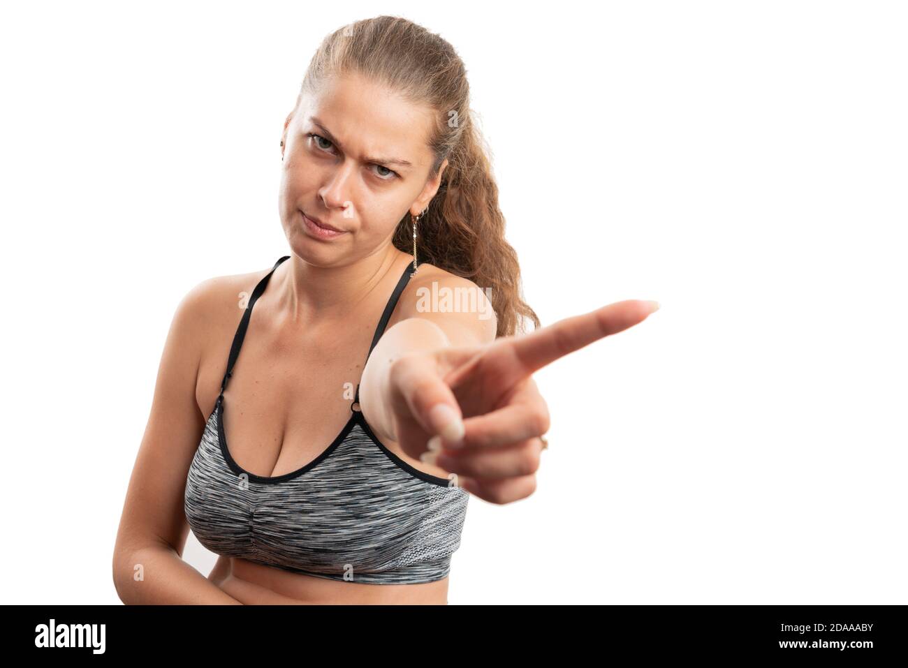 Femme adulte avec expression sérieuse ne faisant aucun geste en utilisant l'index finger dans la salle de gym vêtements de sport isolés sur fond blanc de studio avec espace de copie Banque D'Images