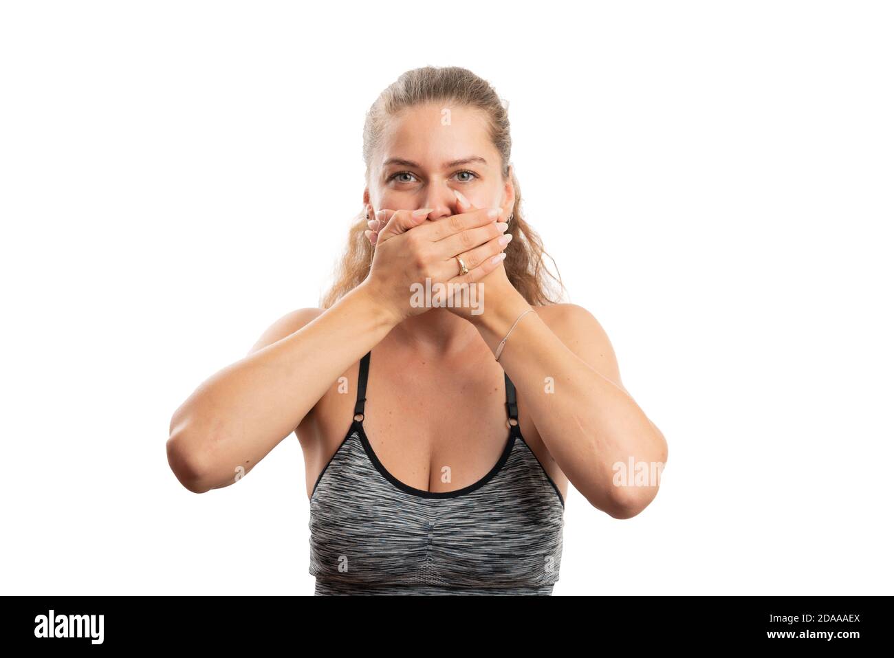 Femme dans les vêtements de sport comme modèle de style de vie actif sain couvrant la bouche utiliser les mains comme secret aucun concept de dire isolé sur blanc arrière-plan du studio Banque D'Images