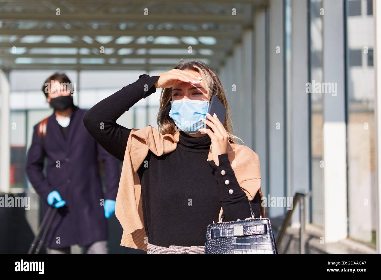 Femme d'affaires en voyage d'affaires avec un smartphone et un masque parce que De la pandémie Covid-19 Banque D'Images
