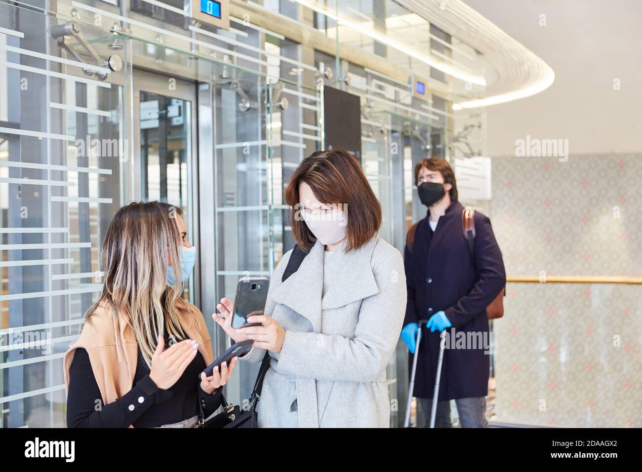Les voyageurs d'affaires disposant d'un smartphone utilisent l'application d'avertissement Corona dans L'événement d'une pandémie Covid-19 Banque D'Images
