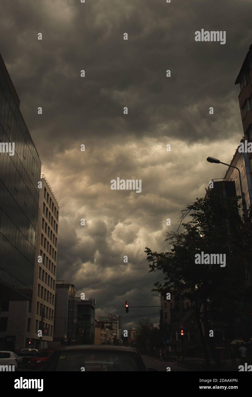 Tempête urbaine, circulation, nuages spectaculaires comme fond, lumière jaune Banque D'Images