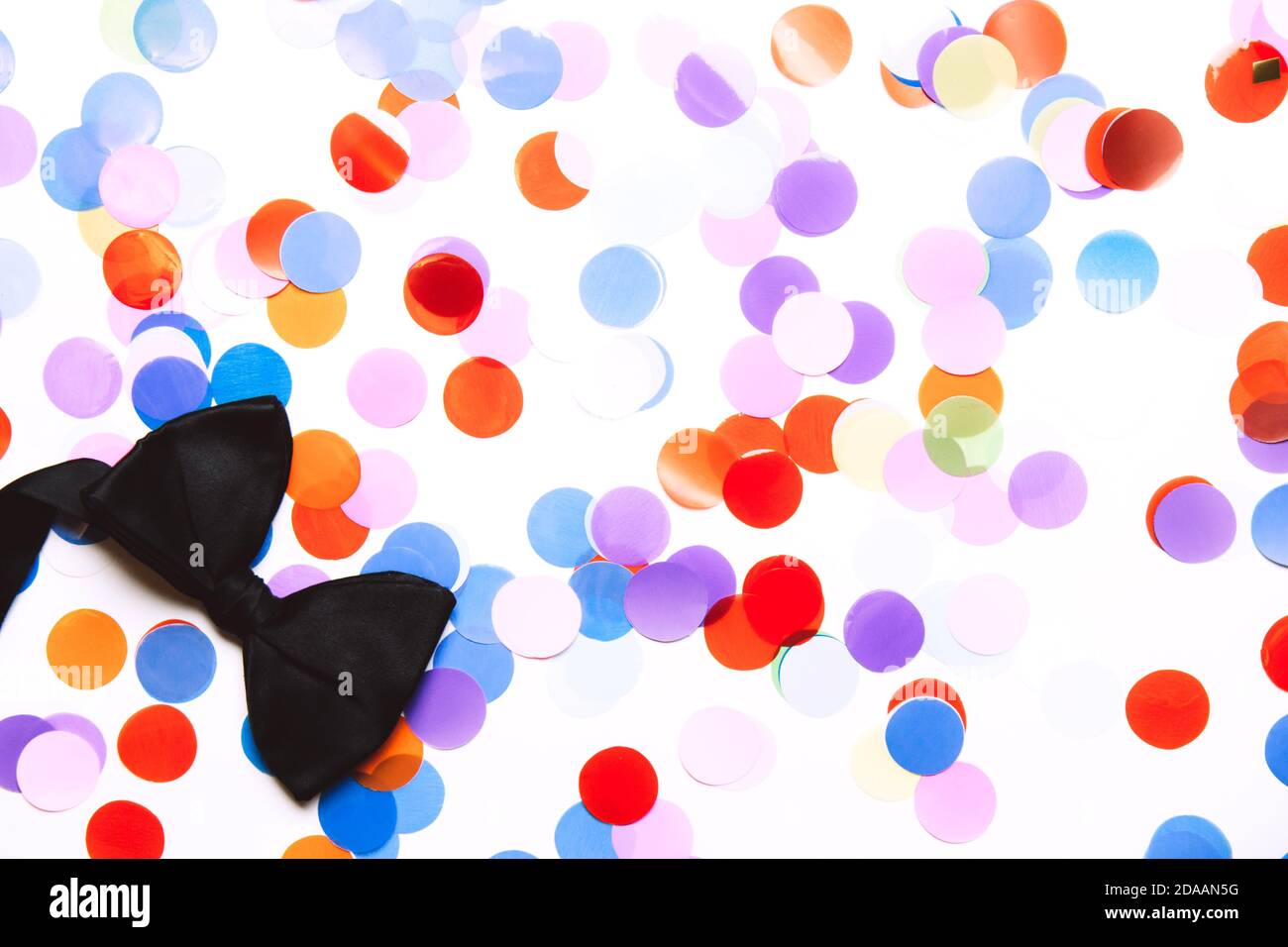 Confettis en papier multicolores festifs sous forme de cercles et noeud  papillon noir isolé sur fond blanc Photo Stock - Alamy