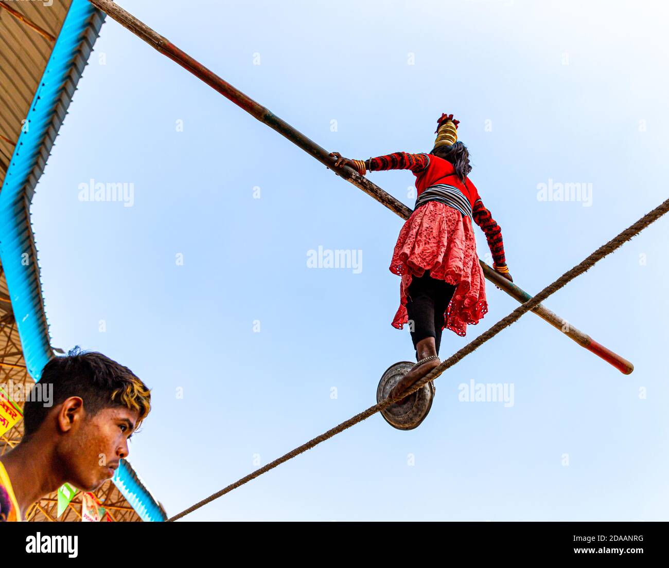 une fille interprète des acrobaties de rue en marchant sur une corde serrée au festival de chameau de pushkar. Banque D'Images