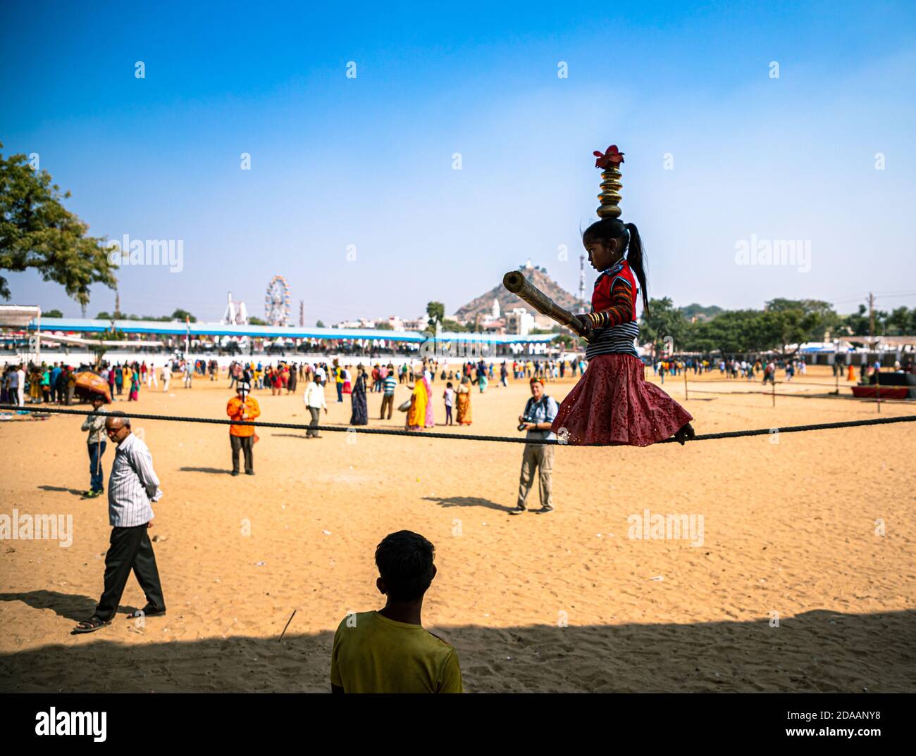 une fille interprète des acrobaties de rue en marchant sur une corde serrée au festival de chameau de pushkar. Banque D'Images