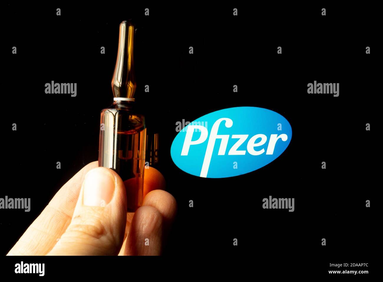 Société pharmaceutique Pfizer de vaccins contre le coronavirus. Logo Pfizer avec vaccin à main. Banque D'Images