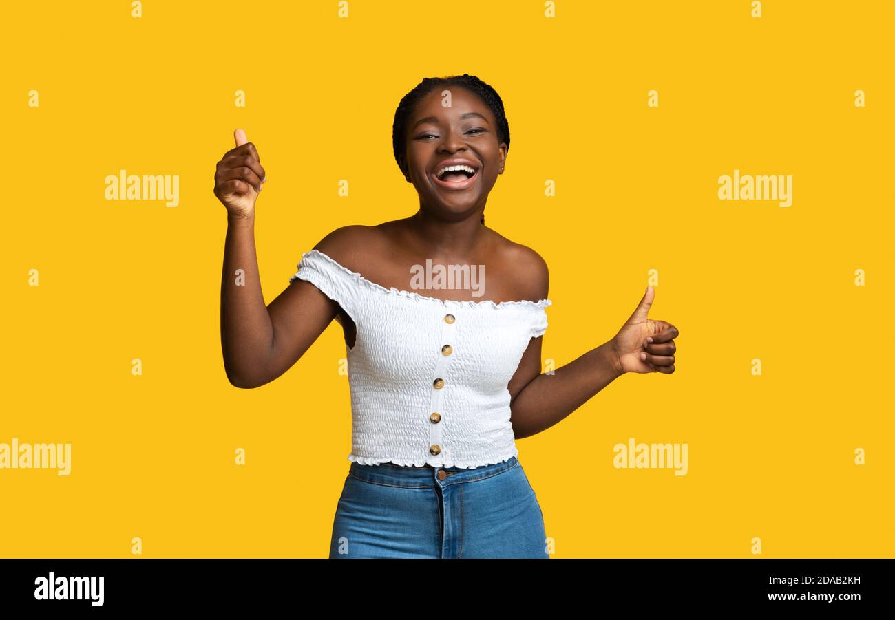 La vie est grande. Joyeuse femme afro-américaine montrant des Thumbs Up à Camera Banque D'Images