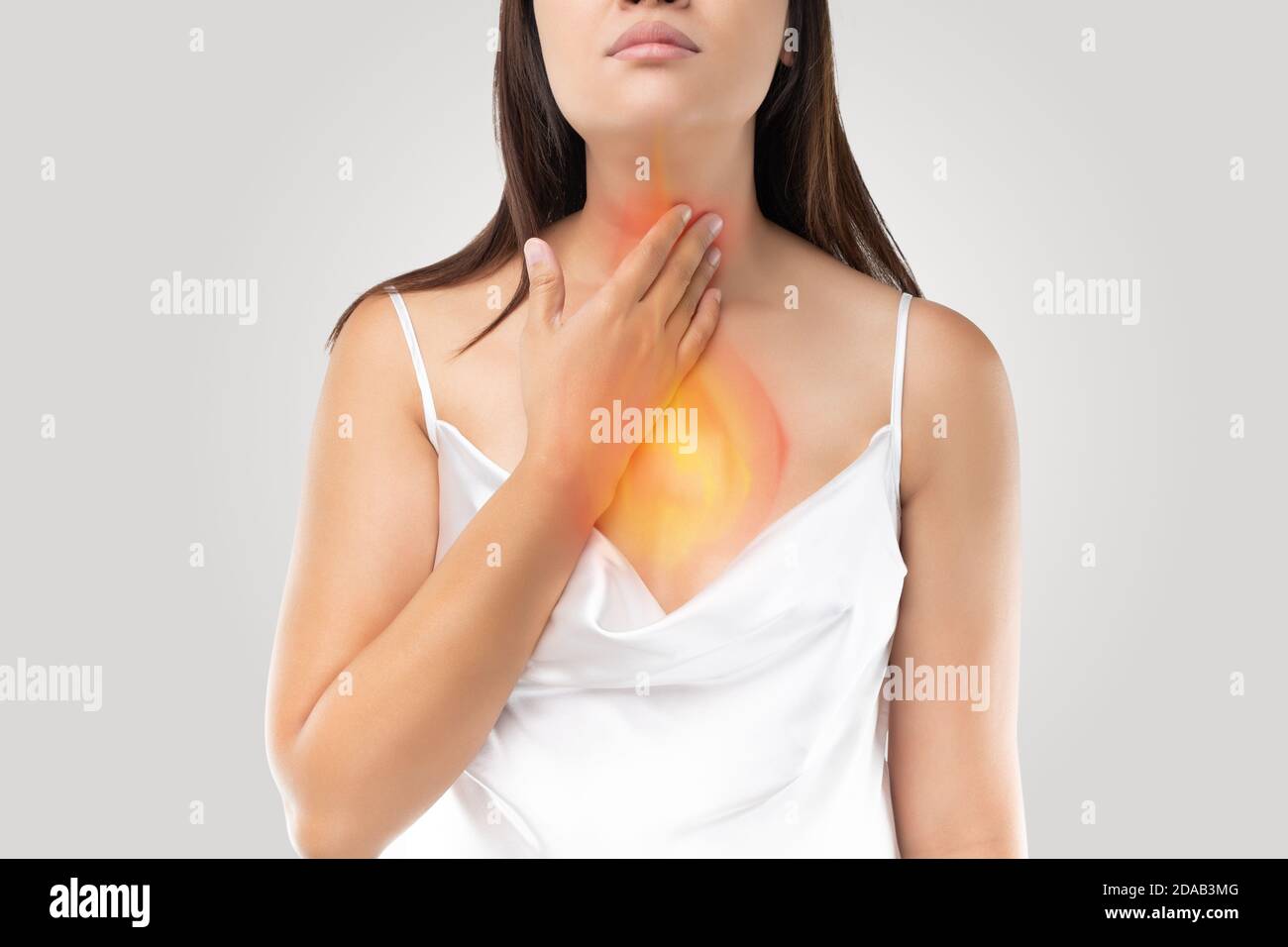 Une femme souffrant de reflux acide ou de brûlures d'estomac sur le gris Arrière-plan Banque D'Images