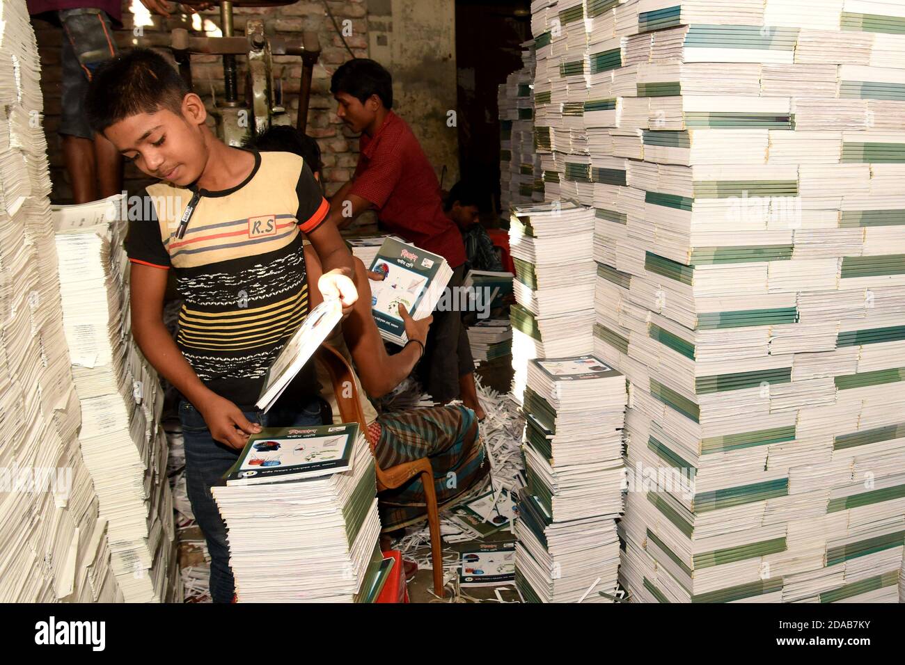 Le 11 novembre 2020, un enfant bangladais travaille dans une usine de reliure à Dhaka, au Bangladesh. Chaque enfant travailleur obtient un salaire de quatre cents T. Banque D'Images