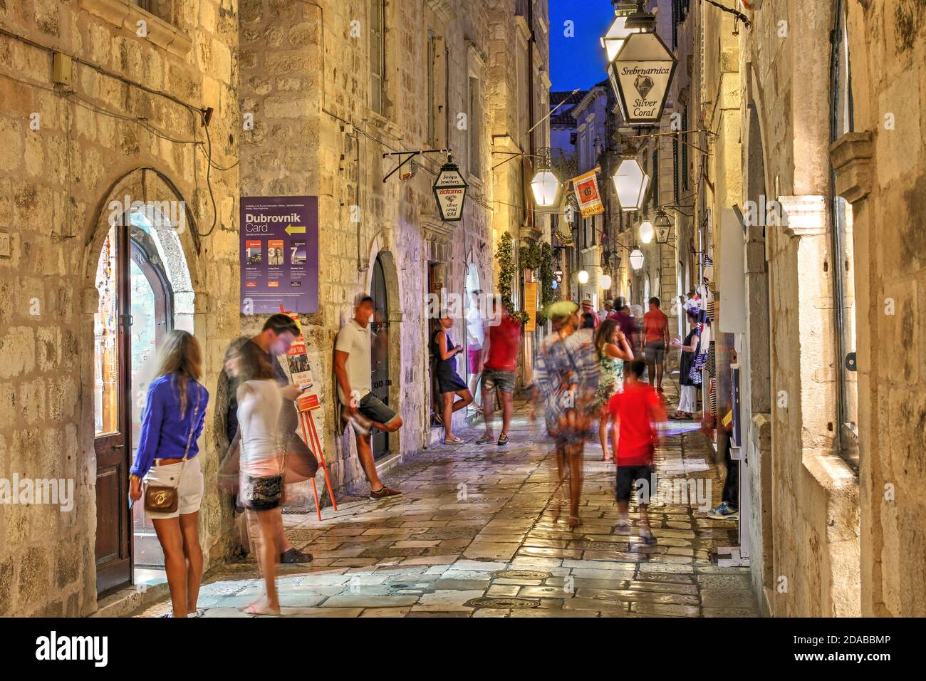 Scène nocturne le long d'une rue étroite dans la vieille ville de Dubrovnik, Croatie, rempli de touristes se baladant et de vérifier les petites boutiques. Banque D'Images