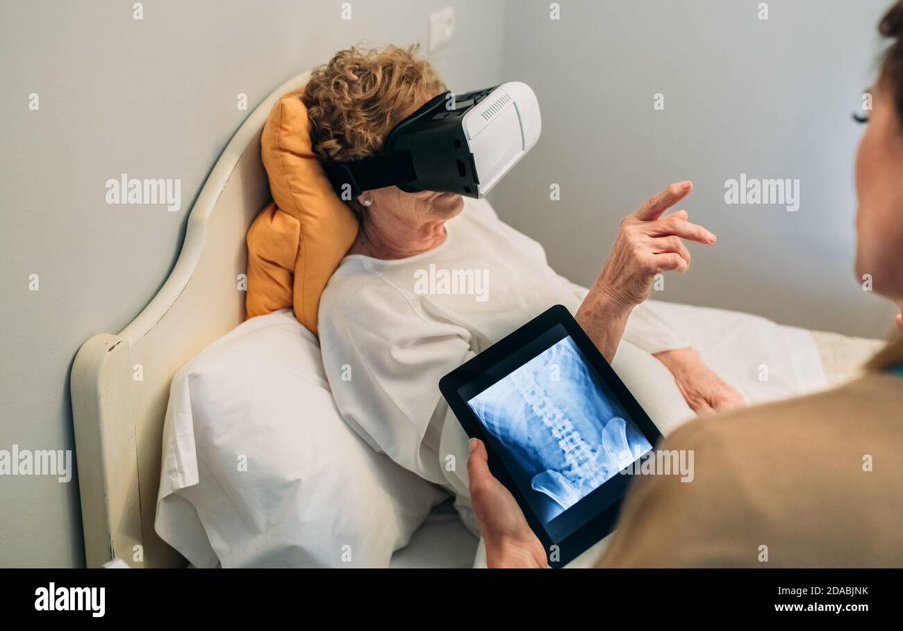 Patient plus âgé utilisant des lunettes de réalité virtuelle Banque D'Images