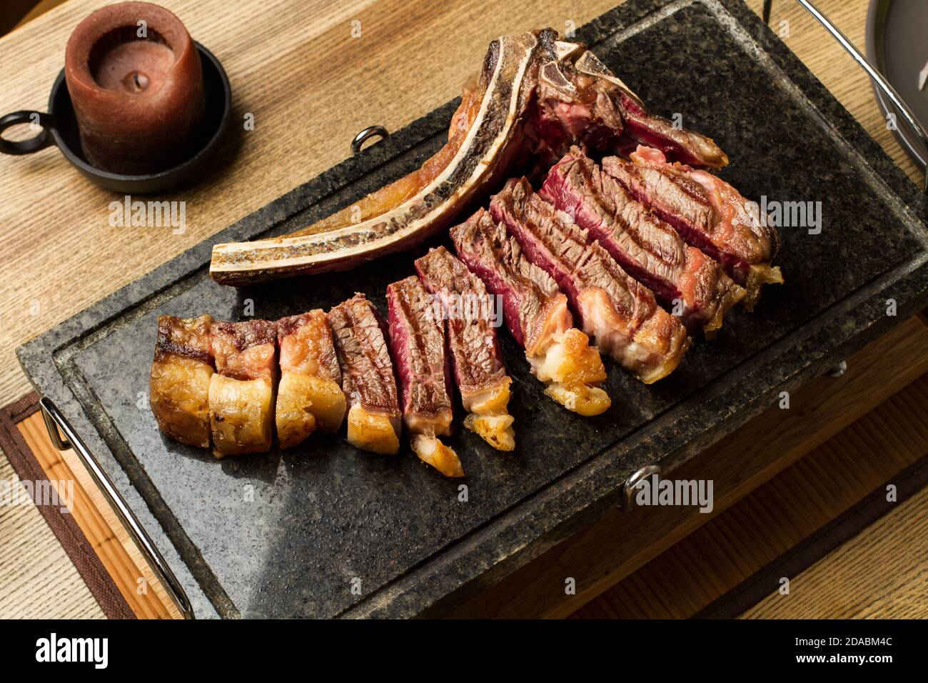 Steak grillé en tranches avec os sur une pierre de cuisson une vue de dessus Banque D'Images