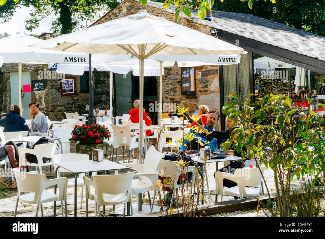 Les pèlerins se reposent et mangent sur la terrasse de l'auberge-restaurant Mercadoiro. French Way, Way of St. James. Mercadoiro, Laxe, Concello de Paradela, Lugo, Galic Banque D'Images