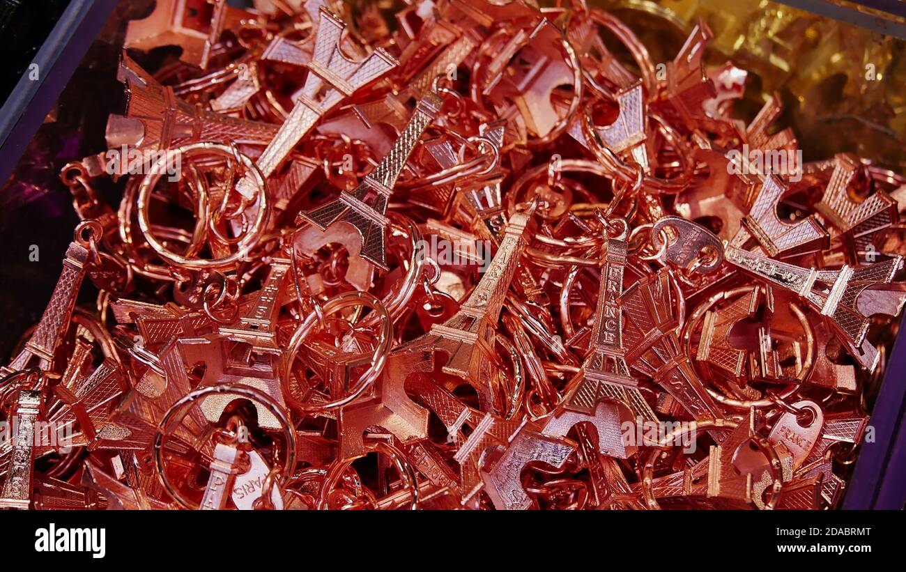 Paris, France - 09/08/2019: Gros plan des miniatures métalliques de la Tour Eiffel de couleur rose vendues aux touristes comme porte-clés souvenir dans la boutique de cadeaux. Banque D'Images