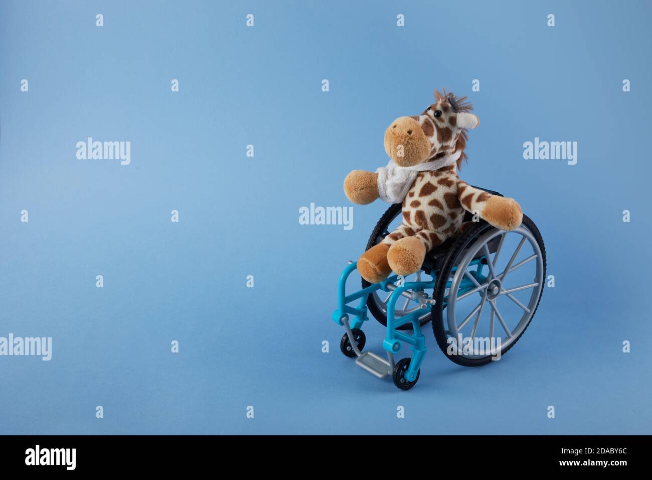 Journée internationale des personnes handicapées. Jouet pour fauteuil roulant sur fond bleu. Banque D'Images