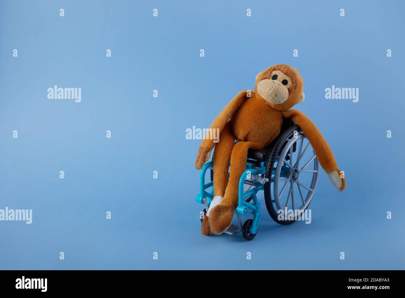 Journée internationale des personnes handicapées. Jouet pour fauteuil roulant sur fond bleu. Banque D'Images