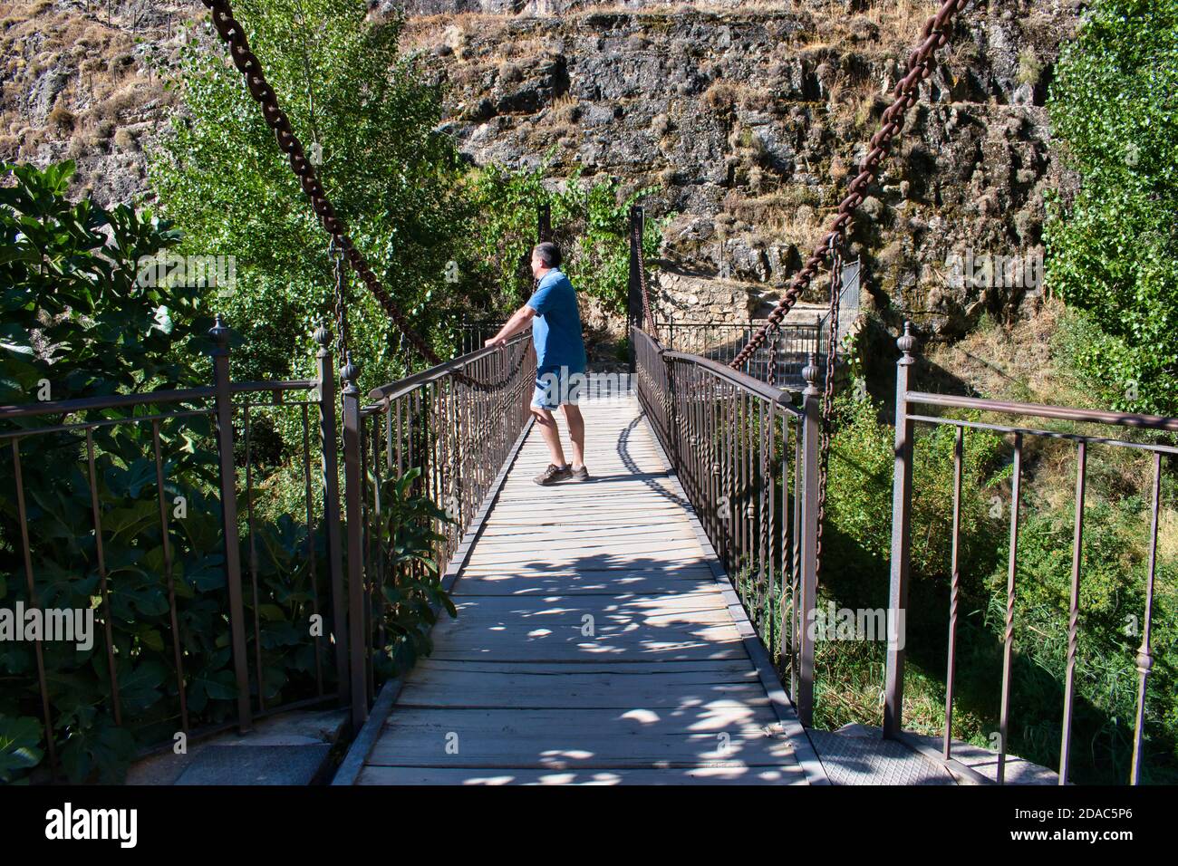 Penchée sur un pont piétonnier au-dessus de la rivière Guadalaviar AS Il traverse la ville d'Albarracin Banque D'Images
