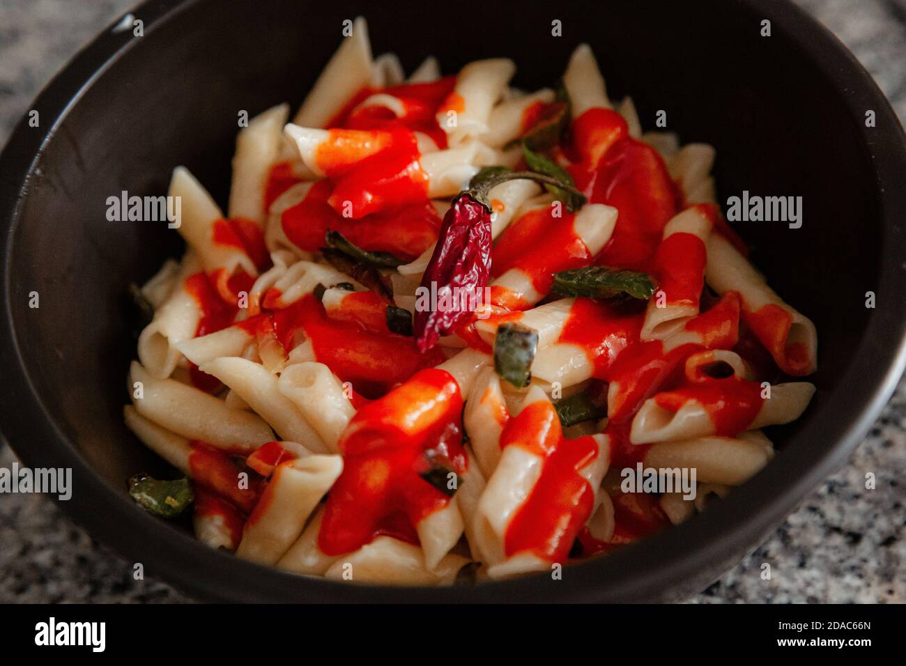 Macaroni blanc à la tomate, au Chili, à l'origan, au fromage et aux épices Banque D'Images