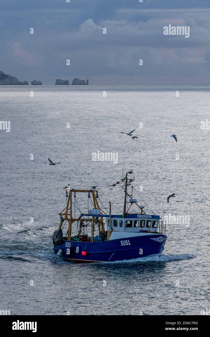 un petit chalutier de pêche côtière qui rentre chez lui en passant par le phare needles sur l'île de wight, au royaume-uni Banque D'Images