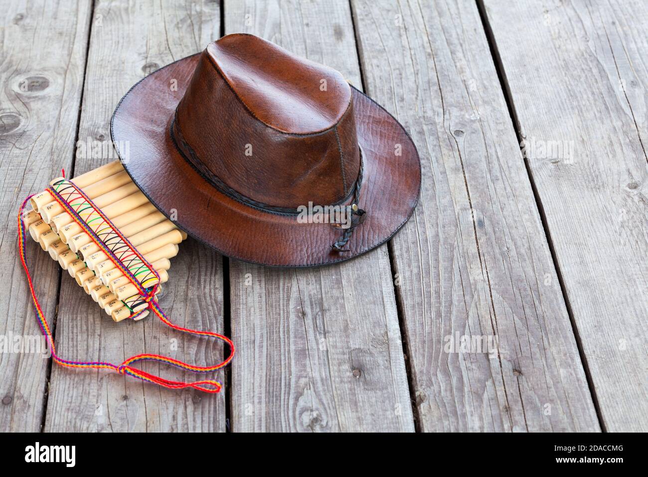 Plusieurs tuyaux flûtes et chapeau de cowboy en cuir couchés sur un sol à bords carrés, espace de copie Banque D'Images