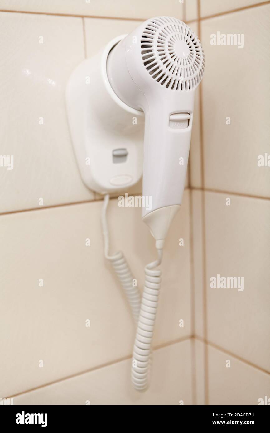 Sèche-cheveux blanc accroché au mur dans la salle de bains Photo Stock -  Alamy